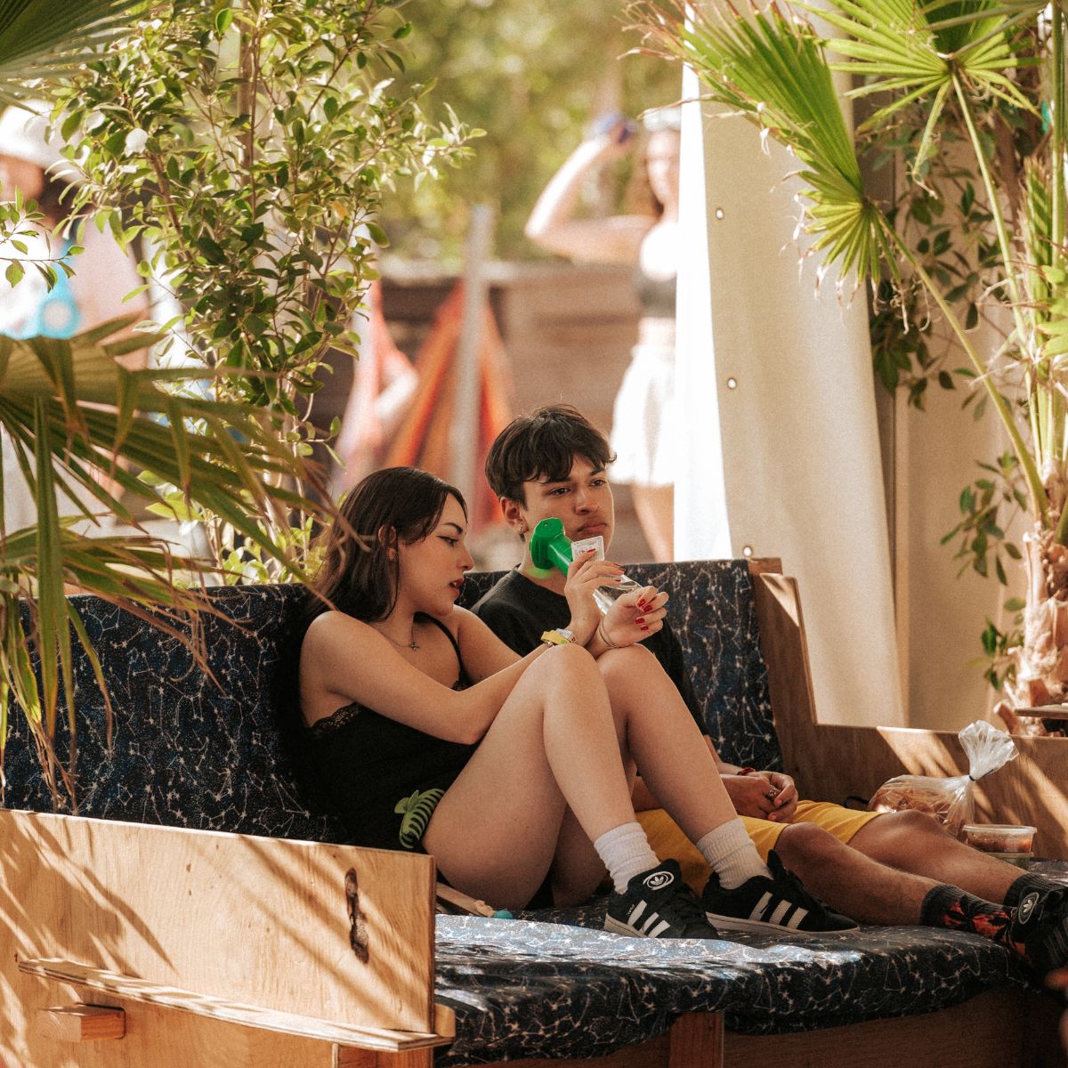 Couple sitting on couch in shady lounge