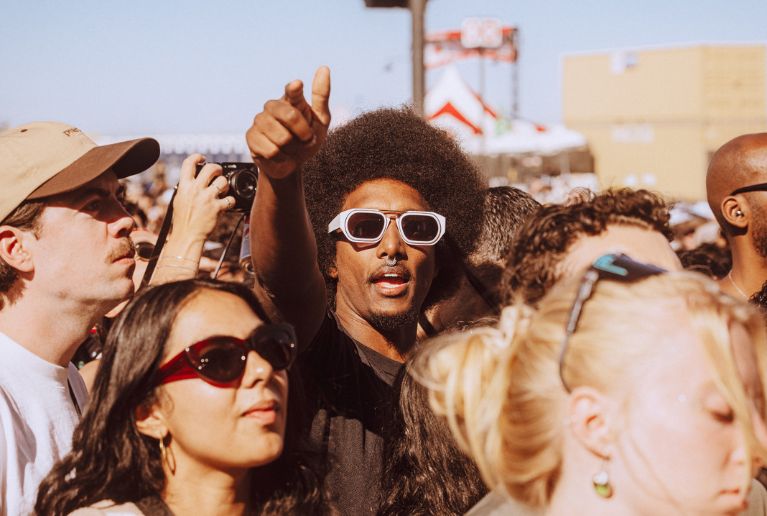 Festival attendee with afro pointing
